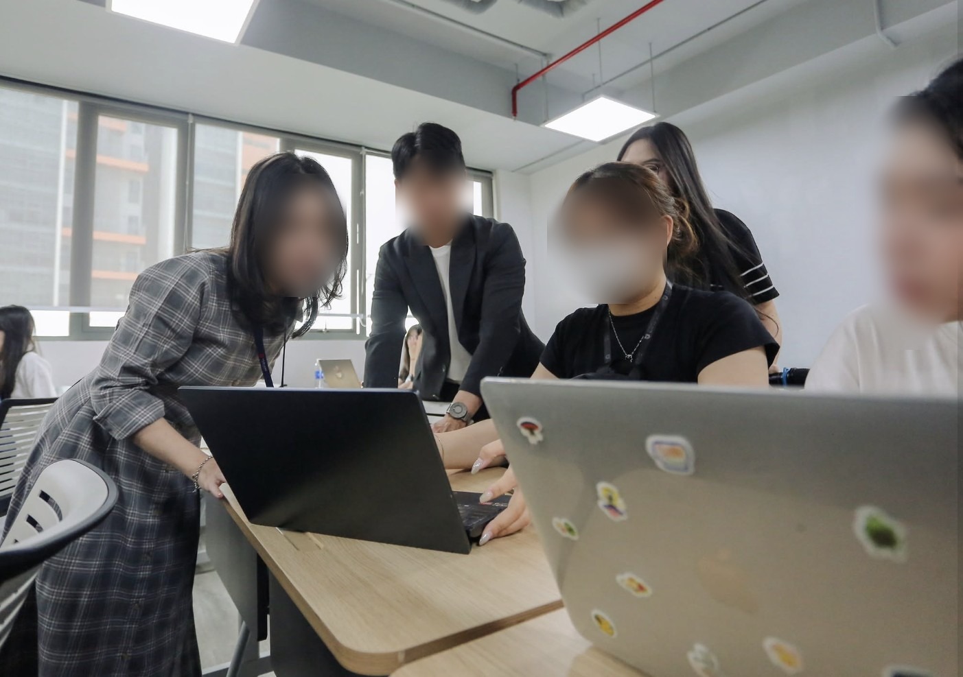 Volunteers helping students during a hands-on AI workshop